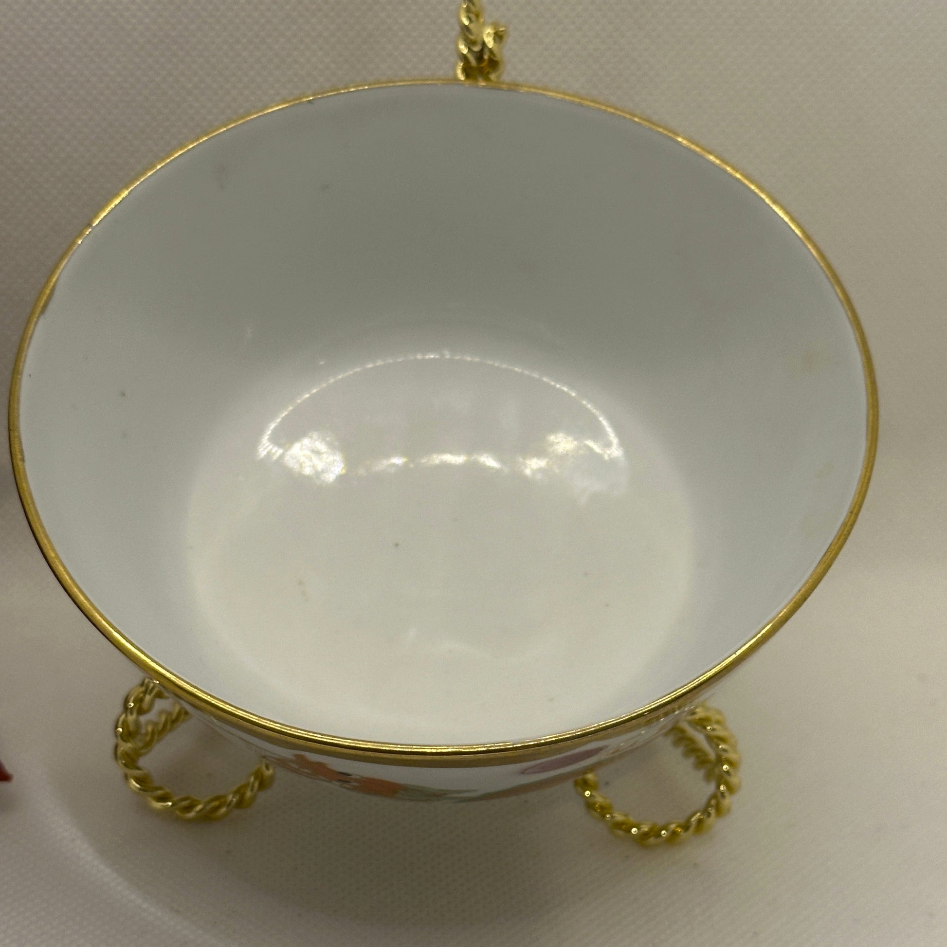 Decorative bowl with gold rim and handles on a plain background