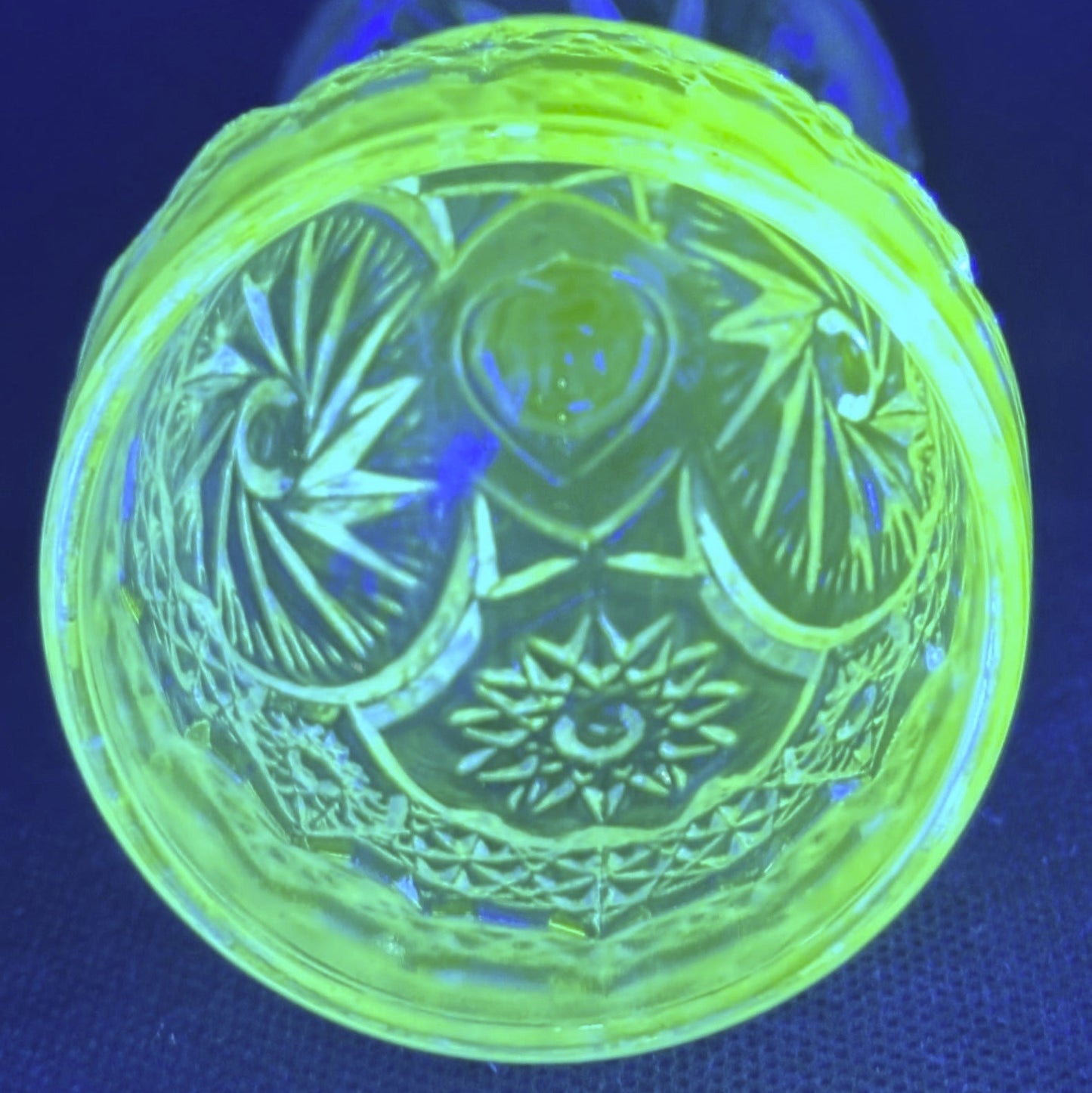 Glowing green glass object with intricate pattern